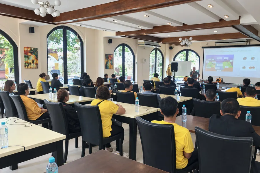 บรรยากาศห้องอบรมมองจากด้านหลัง ผู้เข้าอบรมนั่งเต็มห้องหันหน้าเข้าหาวิทยากรที่ยืนบรรยายหน้าจอฉาย
